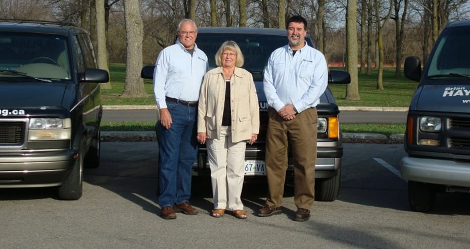 Hayes Plumbing team in front of company vehicles